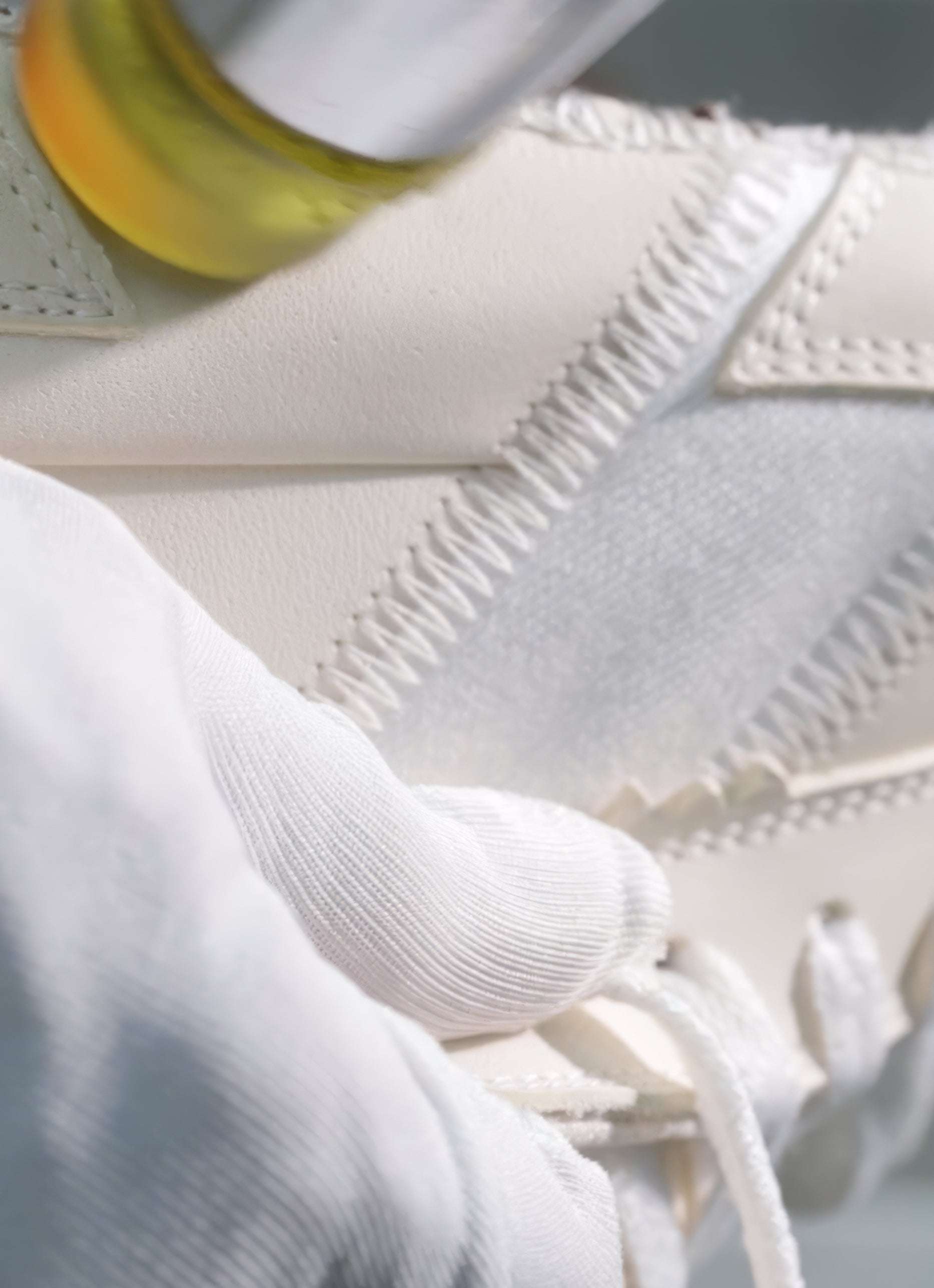 Close-up of a white textured surface with a blurred object in the foreground