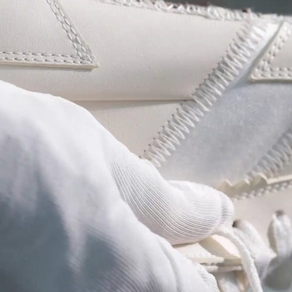 Close-up of white fabric with a textured pattern and stitching detail.